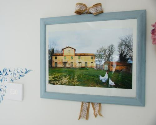 Quadro di una casa rurale con galline, termostato e decorazione murale.