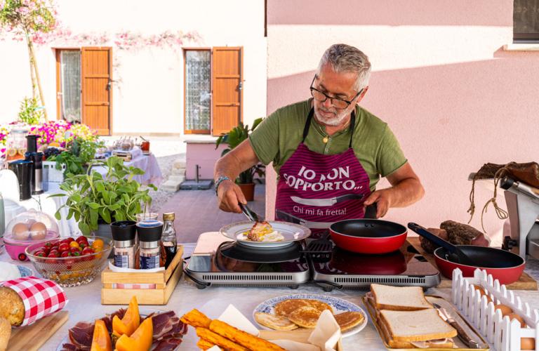 Cesto di pane e frutta fresca su un tavolo con piatti impilati.